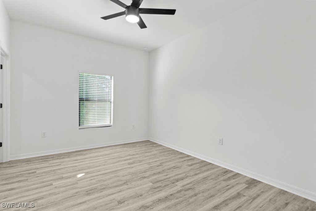 1121 Abrams Boulevard Lehigh Acres, FL 33971 - Photo 34 of 43 wooden floor in an empty room with a window