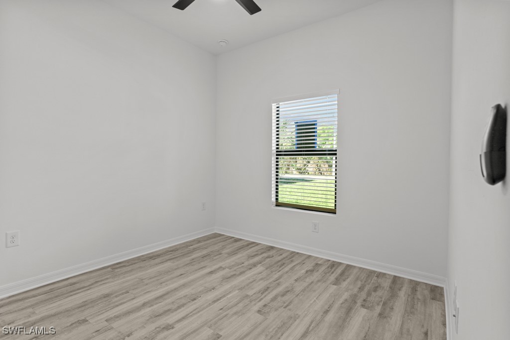 1121 Abrams Boulevard Lehigh Acres, FL 33971 - Photo 5 of 43 a view of empty room with wooden floor and fan