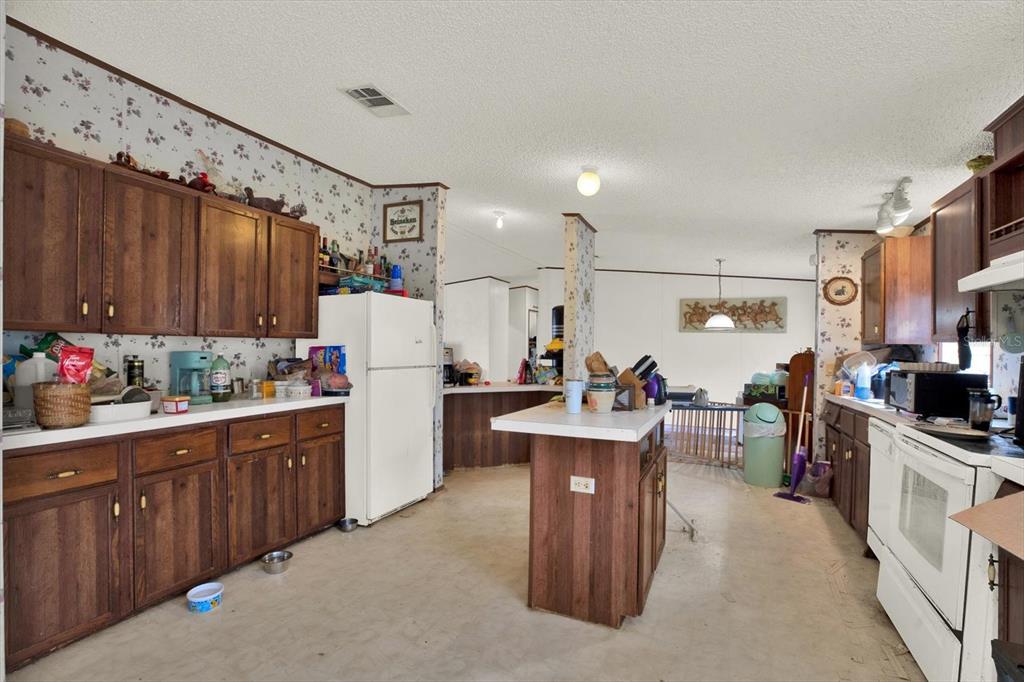 14018 Hexam Road Brooksville, FL 34613 - Photo 7 of 17 a kitchen with cabinets and white appliances
