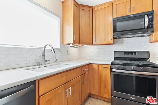 a kitchen with stainless steel appliances a stove sink and microwave