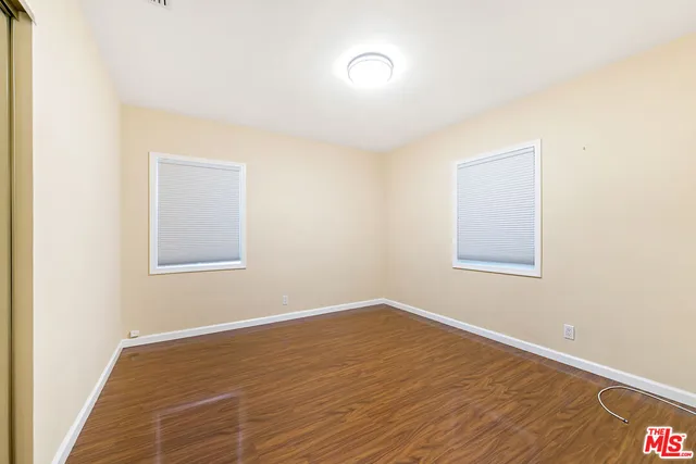 a view of a room with wooden floor and a window