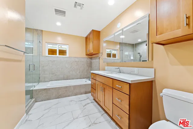 a bathroom with a granite countertop sink toilet and shower