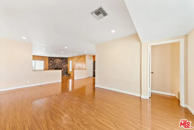 a view of empty room with wooden floor