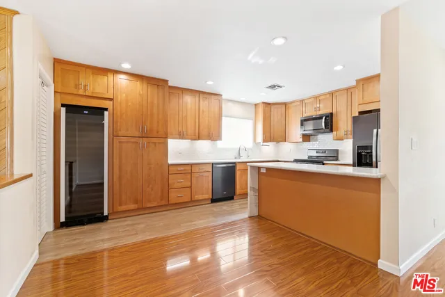 a kitchen with granite countertop a refrigerator and a stove top oven