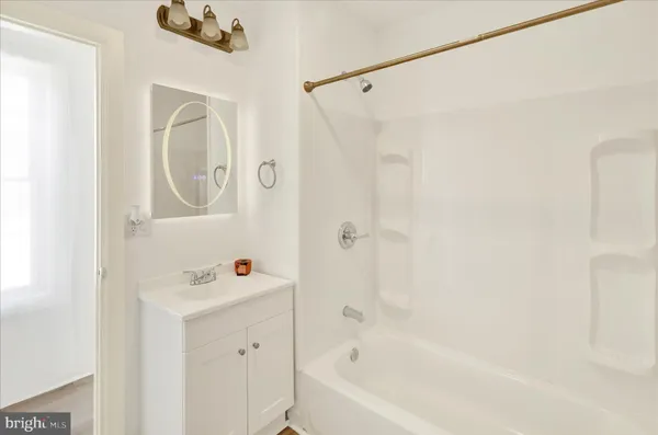 a bathroom with a bathtub a sink a vanity and a shower