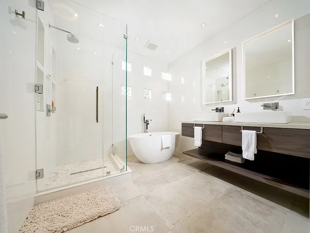 a bathroom with a double vanity sink mirror and shower