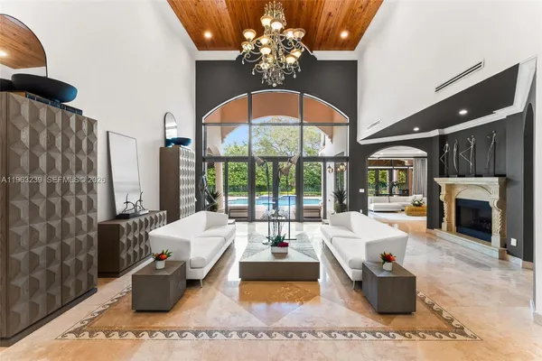 a living room with furniture large window and a chandelier
