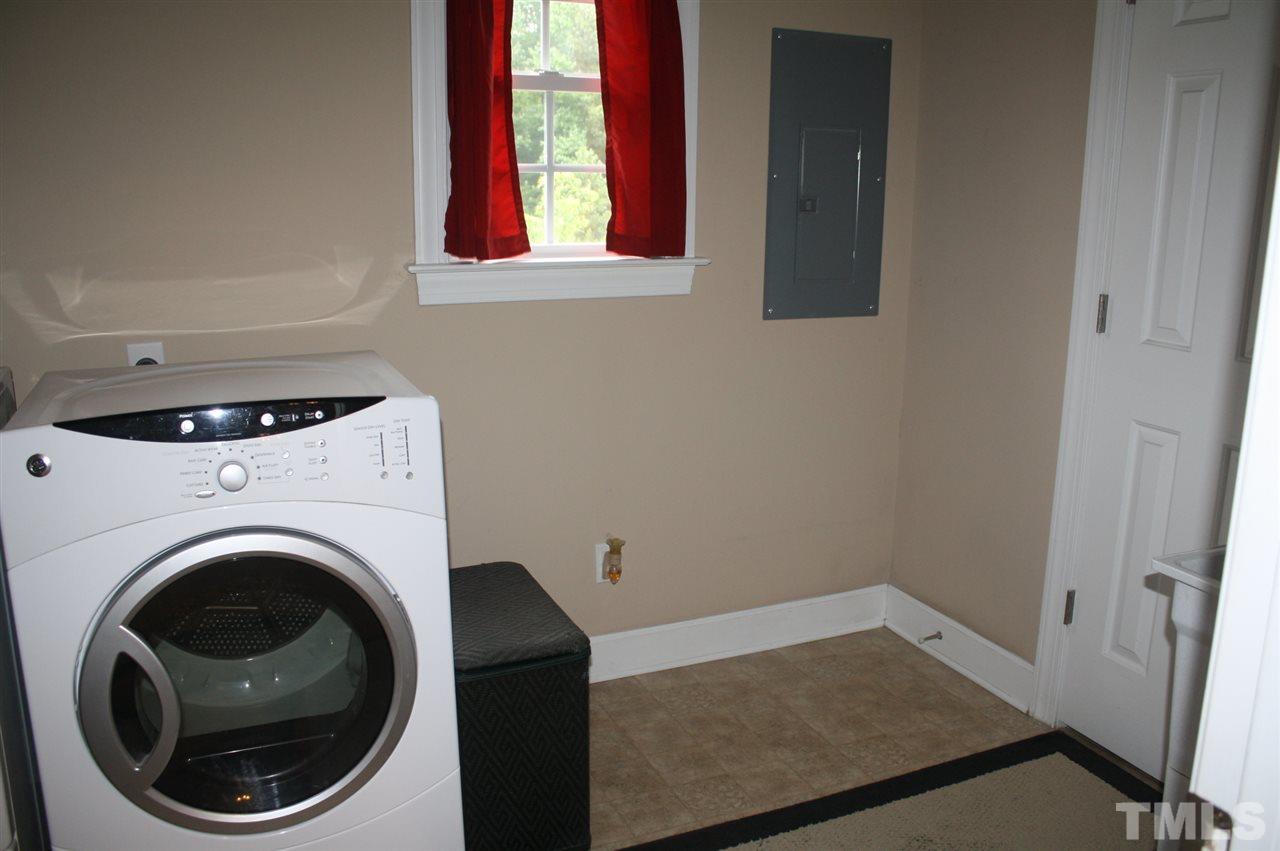 385 Huford Harris Road Spring Hope, NC 27882 - Photo 11 of 25 This spacious first floor utility room features an electric dryer hook up, utility sink, and a window to let in natural lighting. Room provides access to a half bath which has additional shelving for more storage.