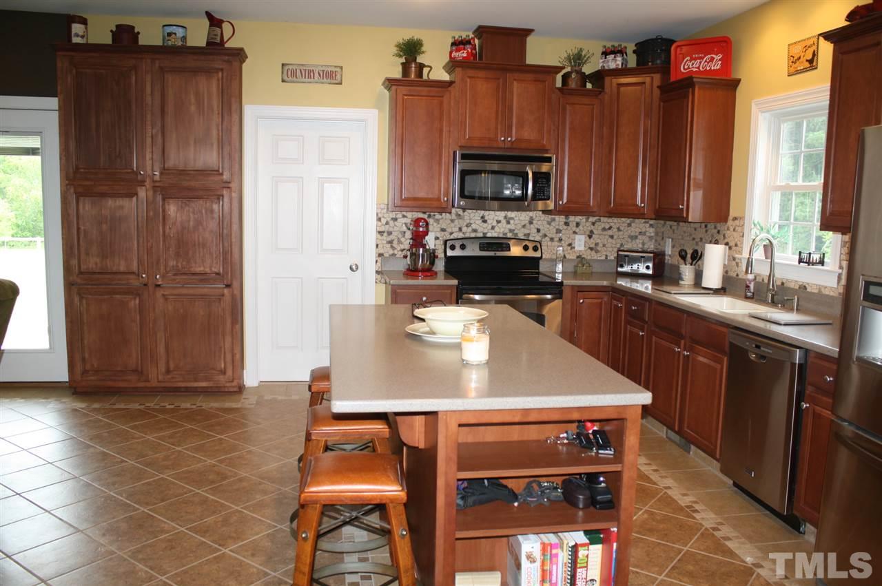 385 Huford Harris Road Spring Hope, NC 27882 - Photo 5 of 25 This lovely kitchen boasts a gorgeous tile floor with a decorative design, beautiful cabinetry, solid surface counter tops, and a decorative back splash. The wall of cabinets serves as a pantry and provides additional storage.