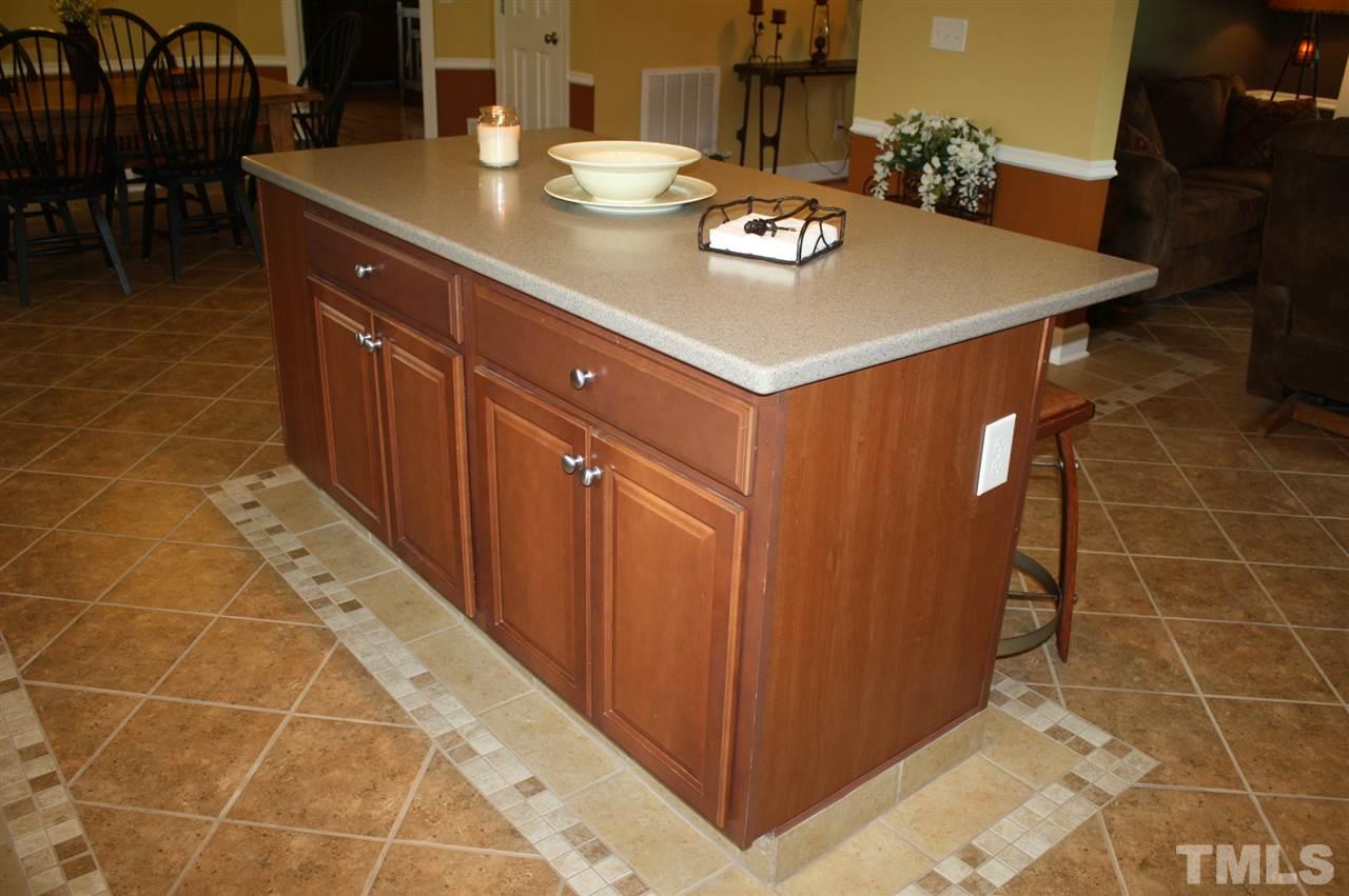 385 Huford Harris Road Spring Hope, NC 27882 - Photo 7 of 25 The large center island provides additional work space for food preparation and additional cabinet space. The bar area provides extra seating when entertaining guests. Note the decorative design in the tile flooring.