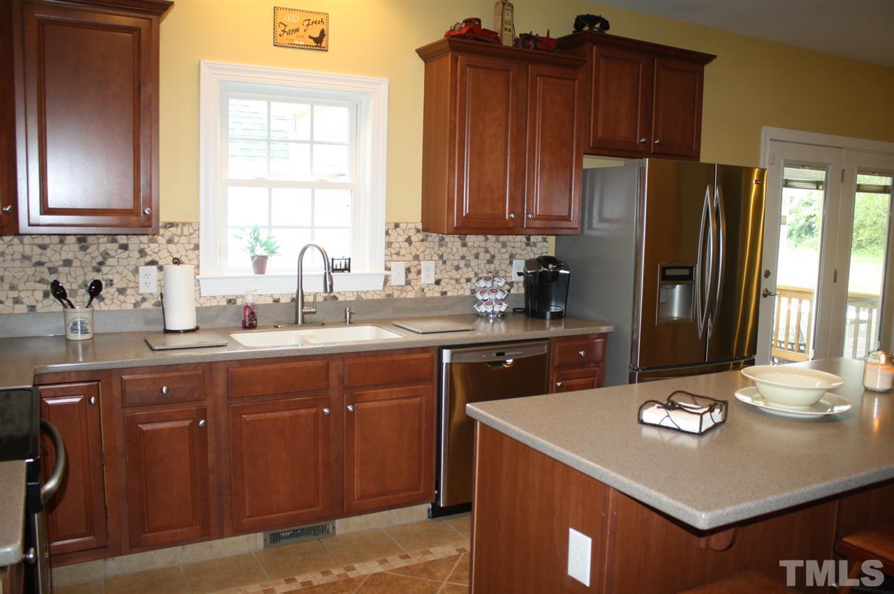 385 Huford Harris Road Spring Hope, NC 27882 - Photo 8 of 25 This well-equipped kitchen features beautiful raised panel cabinets with crown molding which are graced with solid surface counter tops and a decorative back splash. Stainless steel appliances add elegance to this lovely kitchen.