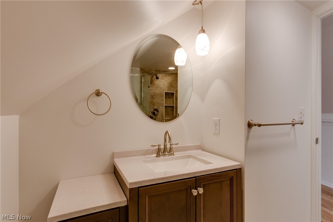 38705 Chardon Road Willoughby Hills, OH 44094 - Photo 14 of 35 Mirror showcases the bathrooms shower shelves complete with towel rods and great vanity and mirror and pendent lighting - this is the upstairs bathroom