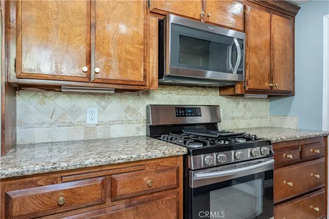 a kitchen with stainless steel appliances granite countertop a stove and a microwave