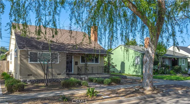 a view of a white house with a tree in front of it