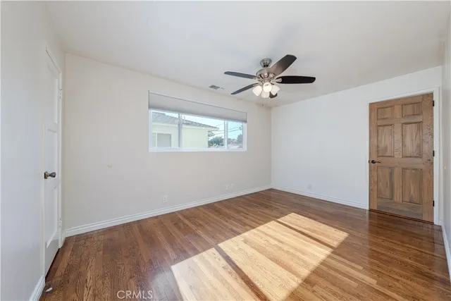 a view of a room with wooden floor and a ceiling fan