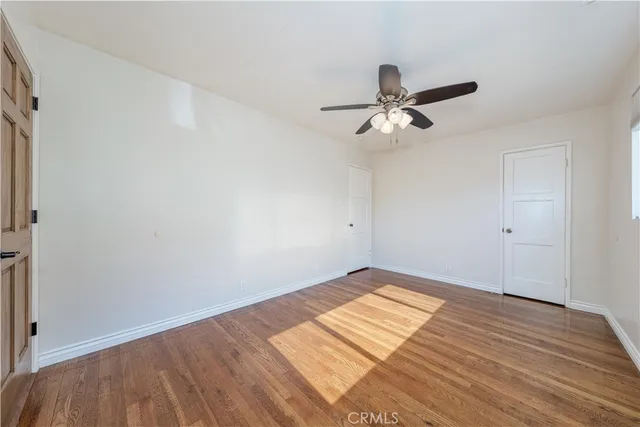 a view of a room with wooden floor and a ceiling fan