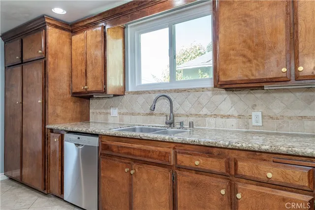 a kitchen with granite countertop cabinets stainless steel appliances and a sink