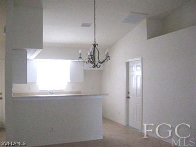 2312 Park Road Lehigh Acres, FL 33971 - Photo 2 of 10 a view of a hallway with a chandelier