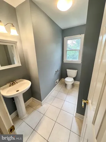 a bathroom with a sink toilet and a mirror