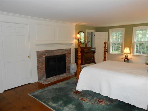 119 Service Road Sandwich, MA 02537 - Photo 14 of 29 a spacious bedroom with a bed and a fireplace