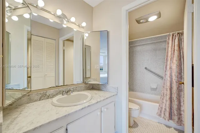 a white bath tub sitting next to a white toilet and a shower curtain