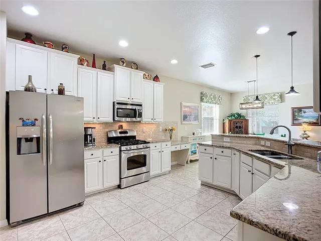 a kitchen with cabinets stainless steel appliances and a counter space