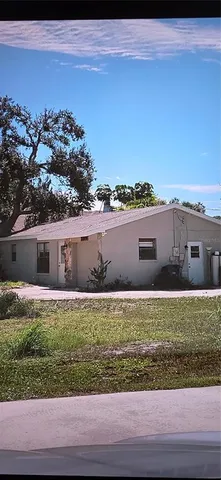 a view of house with yard and car parked