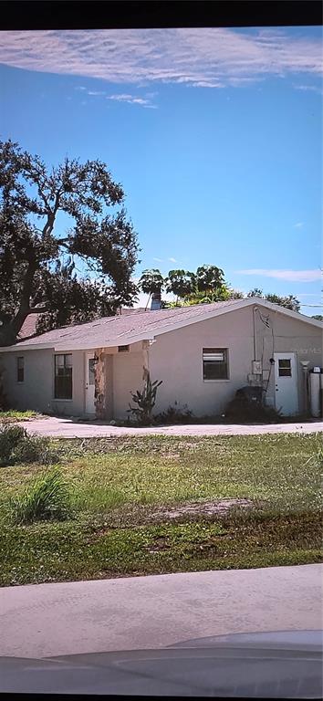 a view of house with yard and car parked