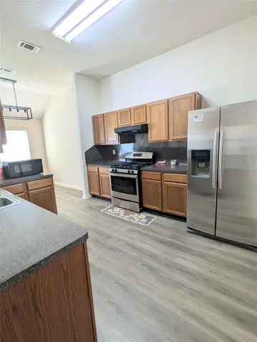 a kitchen with stainless steel appliances a stove a refrigerator and a sink