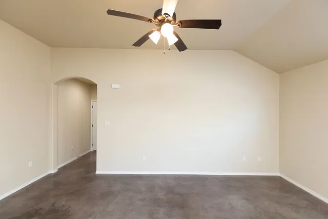 an empty room with closet and a chandelier fan