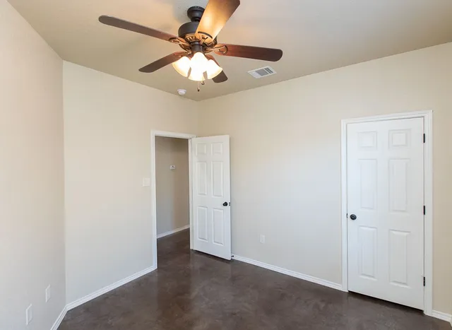 an empty room with a chandelier fan and a chandelier fan