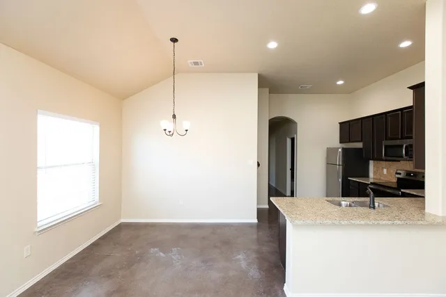 a kitchen with kitchen island a counter top space appliances and a window
