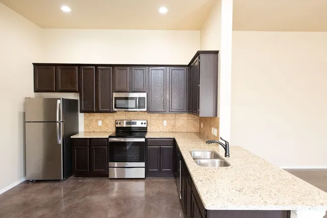 a kitchen with kitchen island a counter top space cabinets and stainless steel appliances