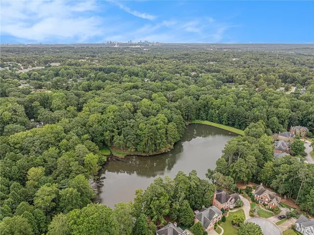 an aerial view of residential houses with outdoor space and trees