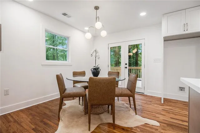 a dining room with furniture a chandelier and wooden floor