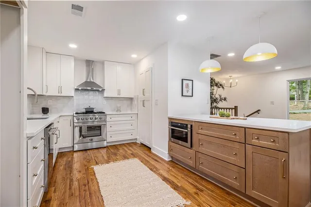 a kitchen with granite countertop a sink cabinets stainless steel appliances and a counter top space