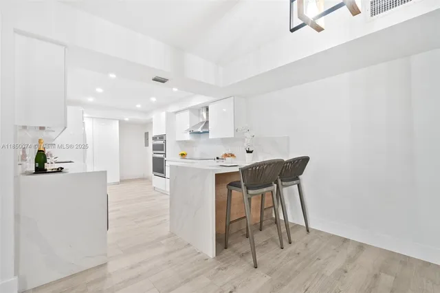 a kitchen with stainless steel appliances a table and chairs in it