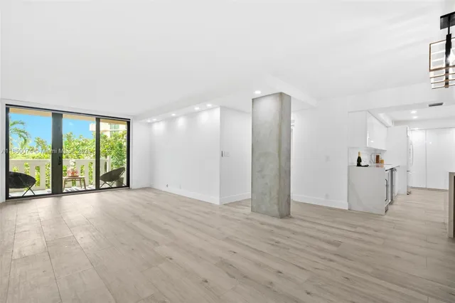 a view of a livingroom with a floor to ceiling window and wooden floor