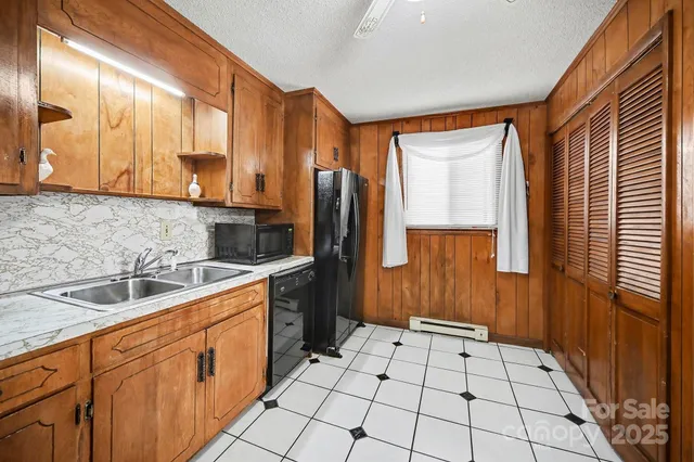 a kitchen with stainless steel appliances a sink cabinets and a window