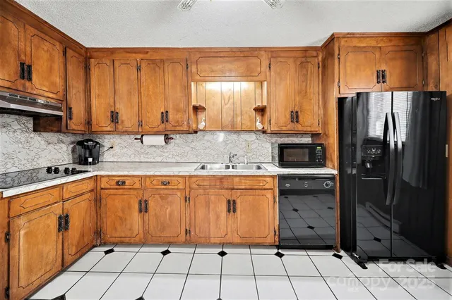 a kitchen with stainless steel appliances granite countertop a refrigerator and a sink