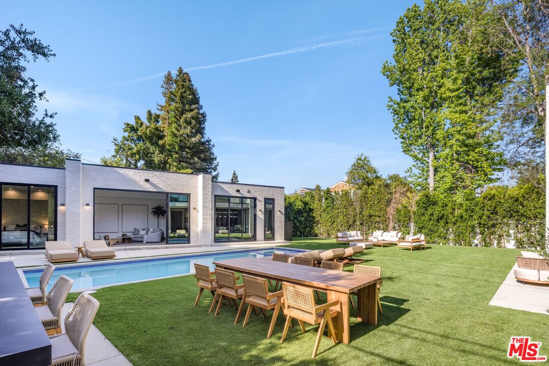17055 Rancho Street Encino, CA 91316 - Photo 42 of 73 a view of a patio with couches and a table and chairs with garden view
