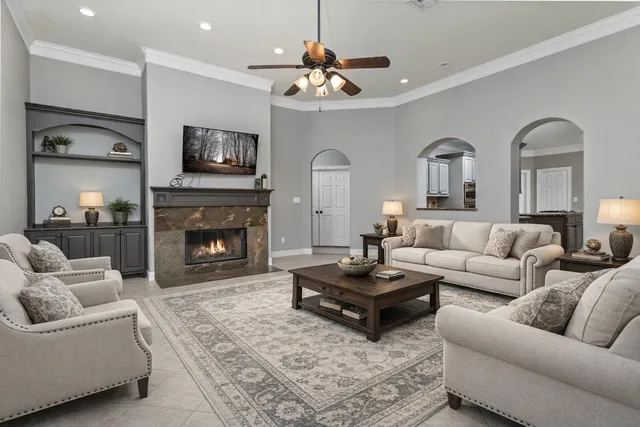 a living room with furniture a fireplace and a flat screen tv