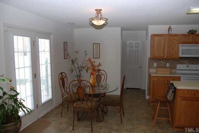 4458 Karlbrook Lane Raleigh, NC 27616 - Photo 5 of 12 View of spacious breakfast area with view of hallway to 1/2 bath, laundry room and garage doors.