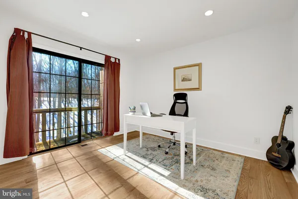 a view of a workspace with furniture and a window