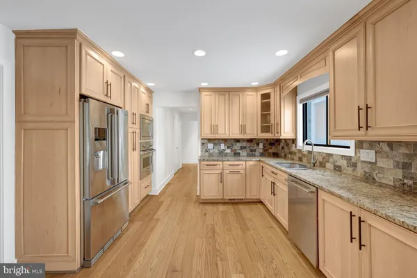 a large kitchen with a lot of counter space and wooden floor