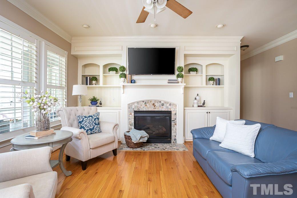 8348 Wheatstone Lane Raleigh, NC 27613 - Photo 4 of 9 a living room with furniture a flat screen tv and a fireplace