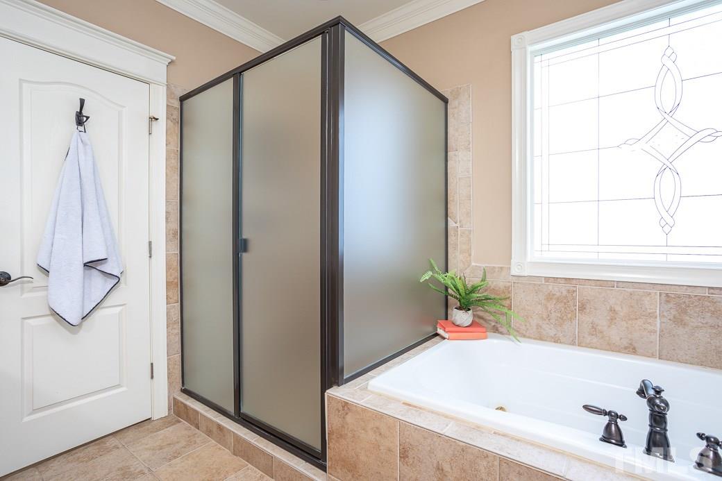 8348 Wheatstone Lane Raleigh, NC 27613 - Photo 6 of 9 a bathroom with a tub and a shower