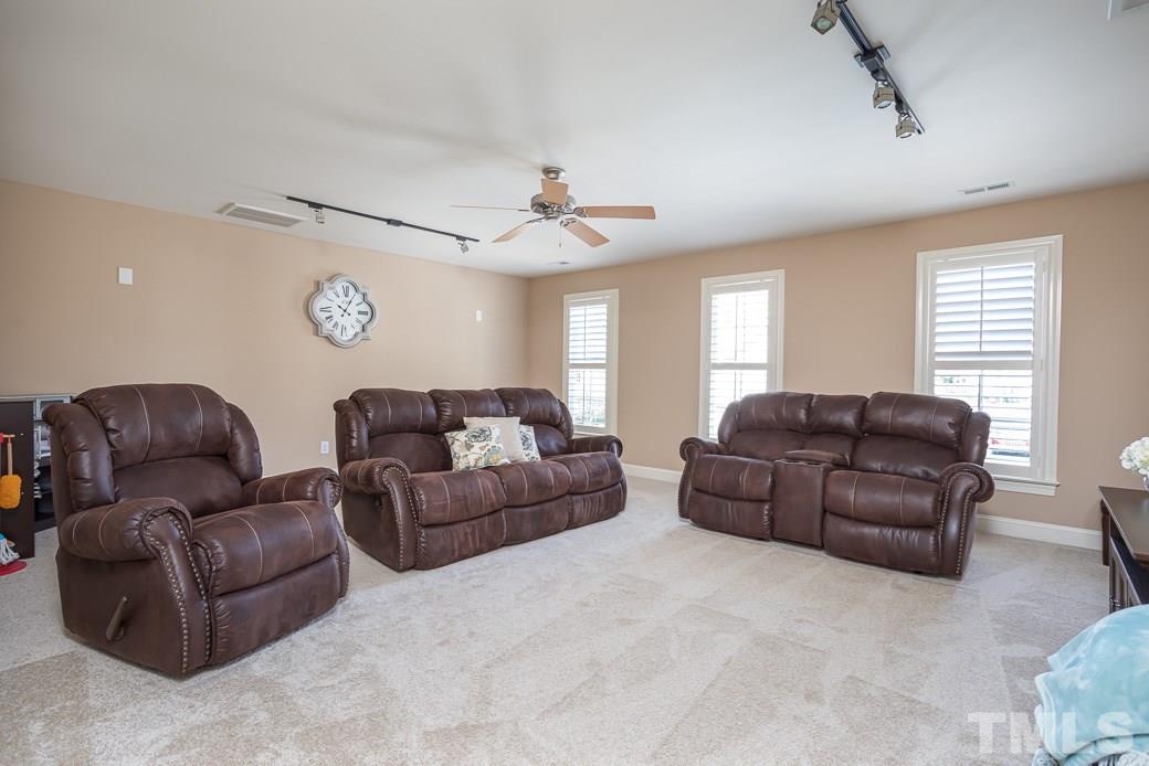8348 Wheatstone Lane Raleigh, NC 27613 - Photo 8 of 9 a living room with couches and a ceiling fan with wooden floor