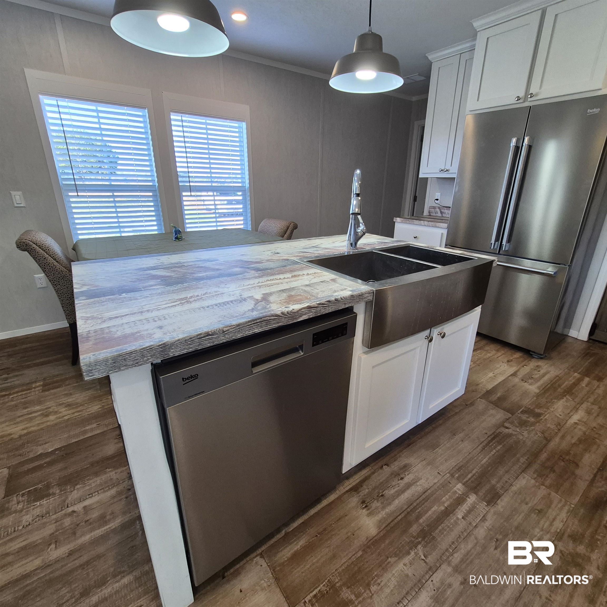 8867 Old Stage Road Repton, AL 36475 - Photo 12 of 37 Kitchen featuring appliances with stainless steel finishes, white cabinetry, an island with sink, hanging light fixtures, and light stone counters