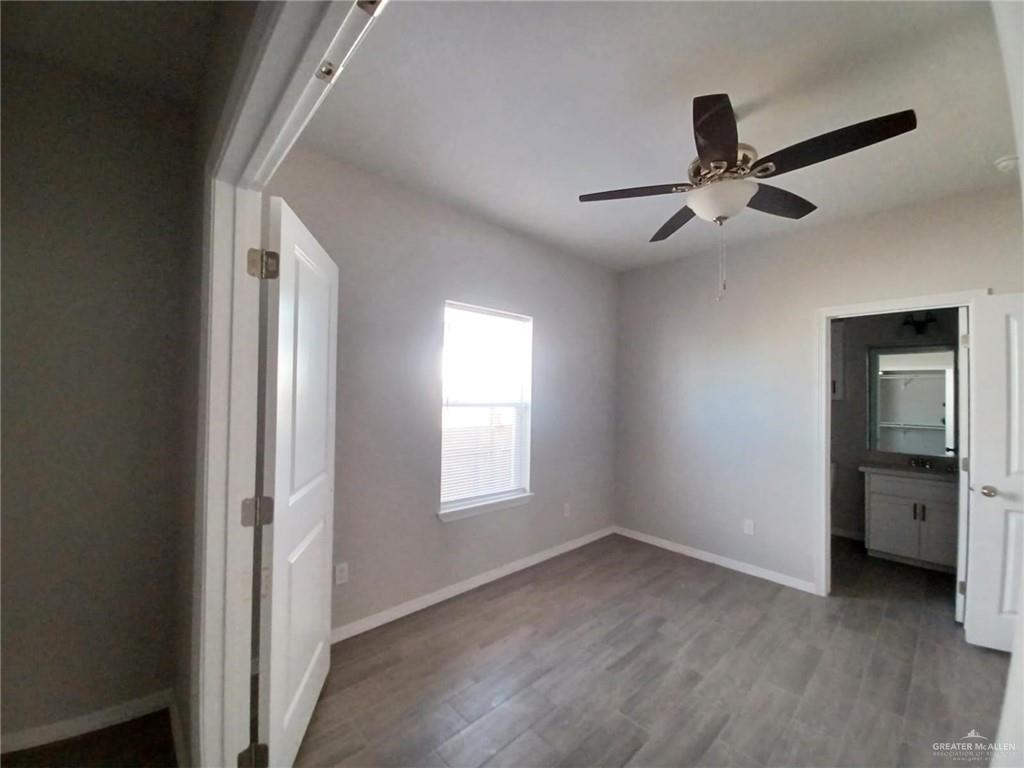 1506 Playa Drive, Unit 1 Weslaco, TX 78596 - Photo 4 of 9 a view of empty room with wooden floor and fan